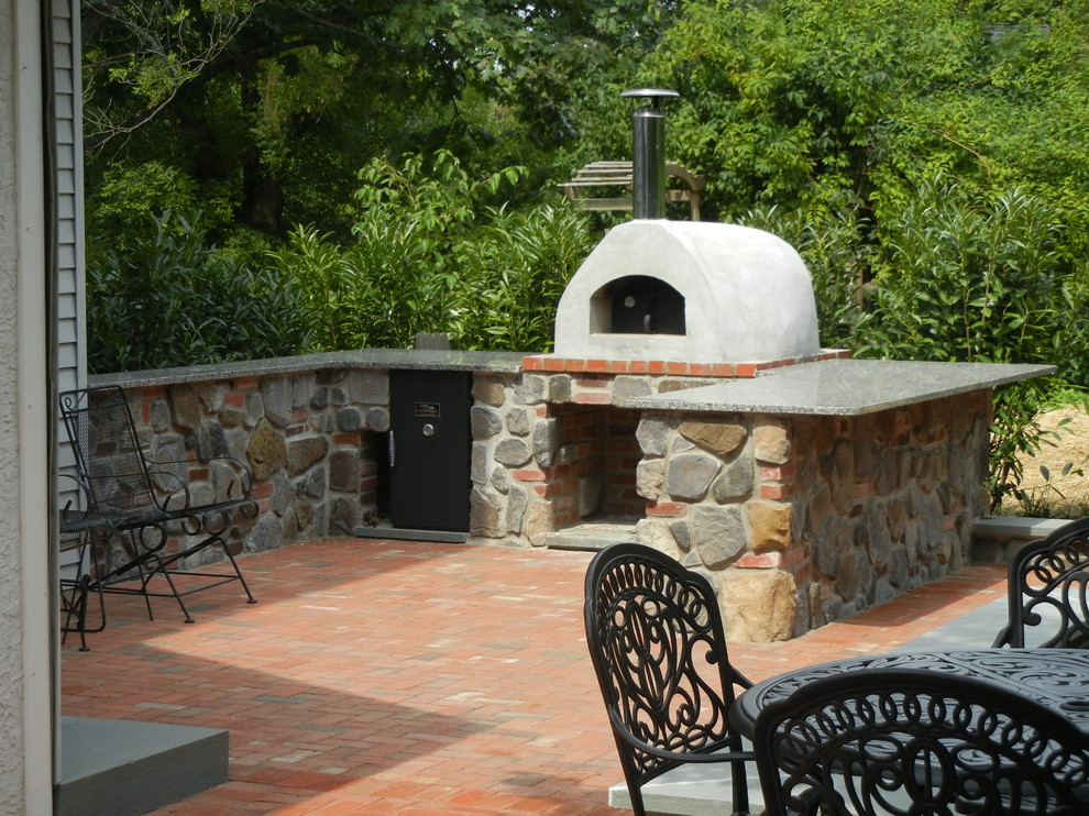 Inspiration for a mid-sized country backyard patio in Philadelphia with an outdoor kitchen, brick pavers and no cover.