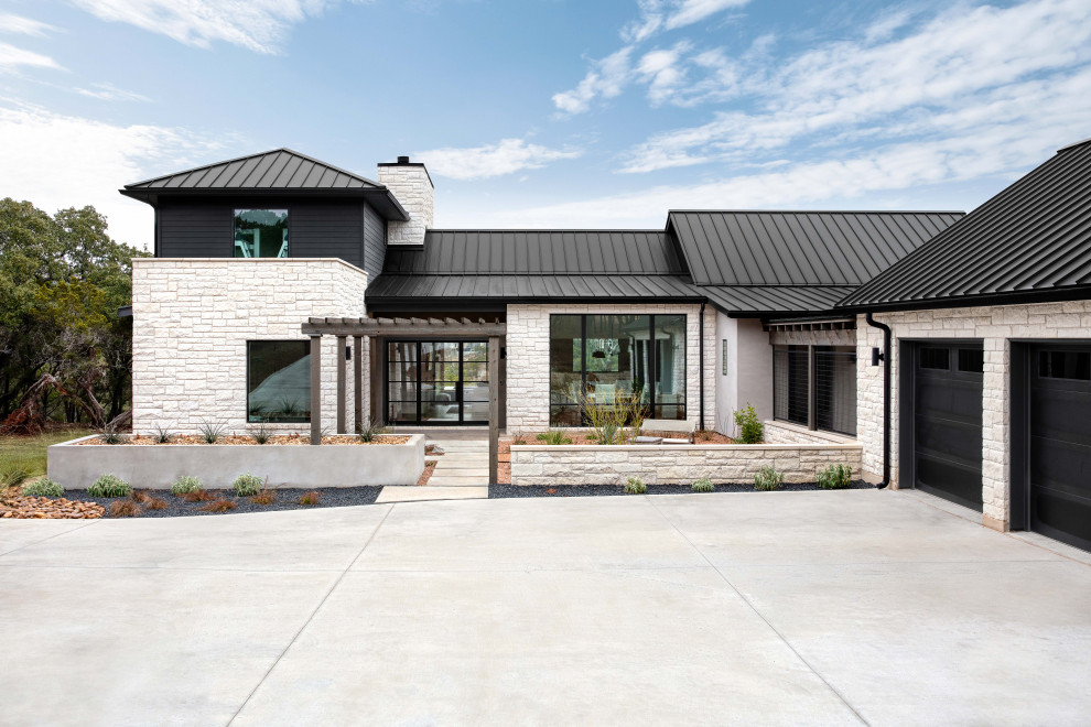 Inspiration for a two-storey house exterior in Austin with mixed siding, a metal roof and a black roof.