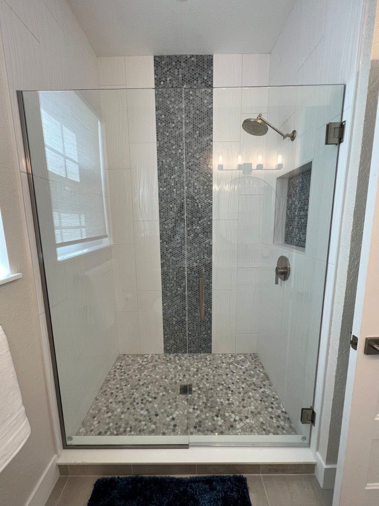Inspiration for a small modern white tile and ceramic tile mosaic tile floor, multicolored floor and single-sink alcove shower remodel in Orlando with shaker cabinets, white cabinets, a one-piece toilet, beige walls, an undermount sink, quartzite countertops, a hinged shower door, gray countertops, a niche and a built-in vanity