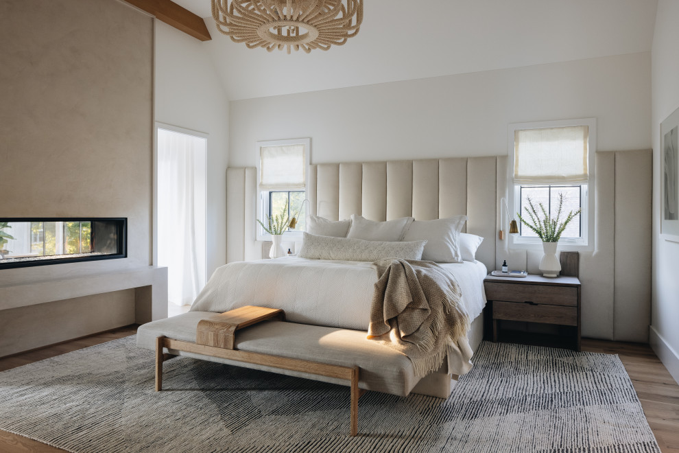 Inspiration for a contemporary master bedroom in Chicago with white walls, medium hardwood floors, a ribbon fireplace and brown floor.