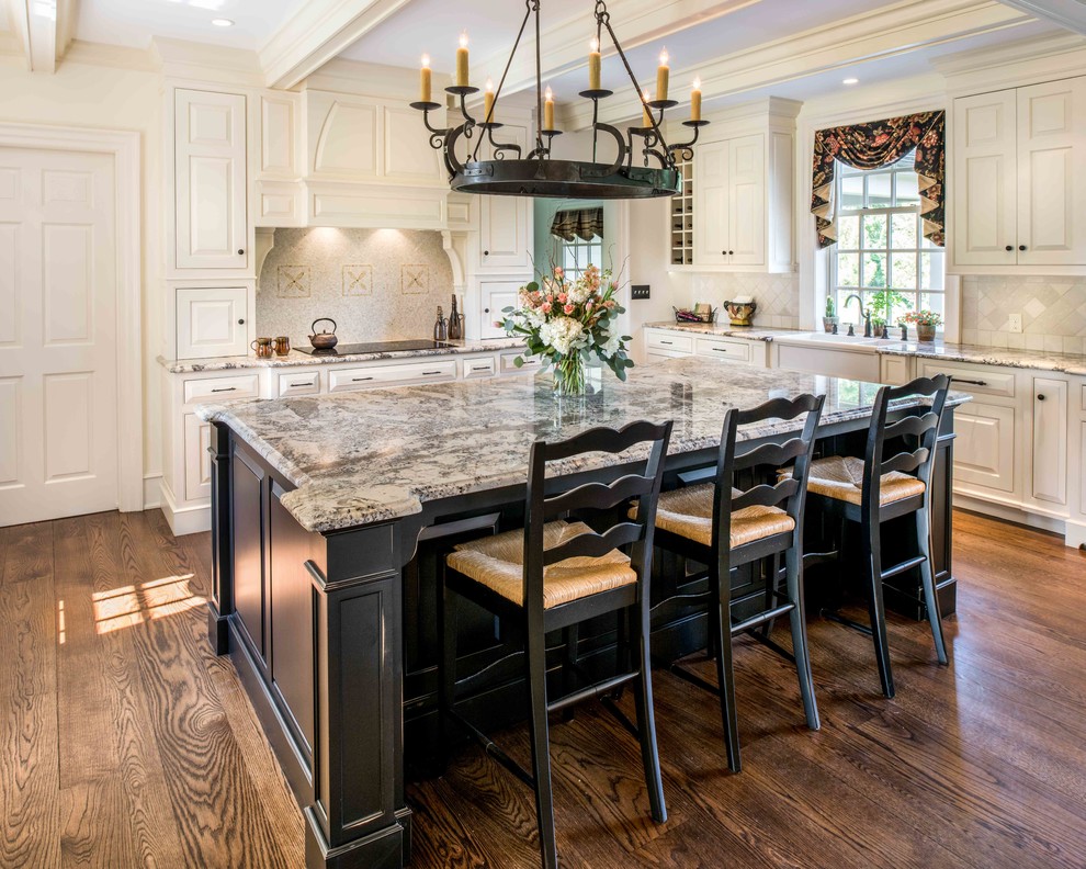 Inspiration for a large traditional l-shaped open plan kitchen in Philadelphia with a farmhouse sink, raised-panel cabinets, white cabinets, granite benchtops, white splashback, panelled appliances, dark hardwood floors, with island and brown floor.