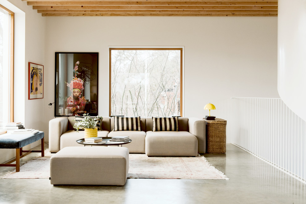 Photo of a contemporary loft-style living room in Stockholm with white walls, concrete floors and grey floor.