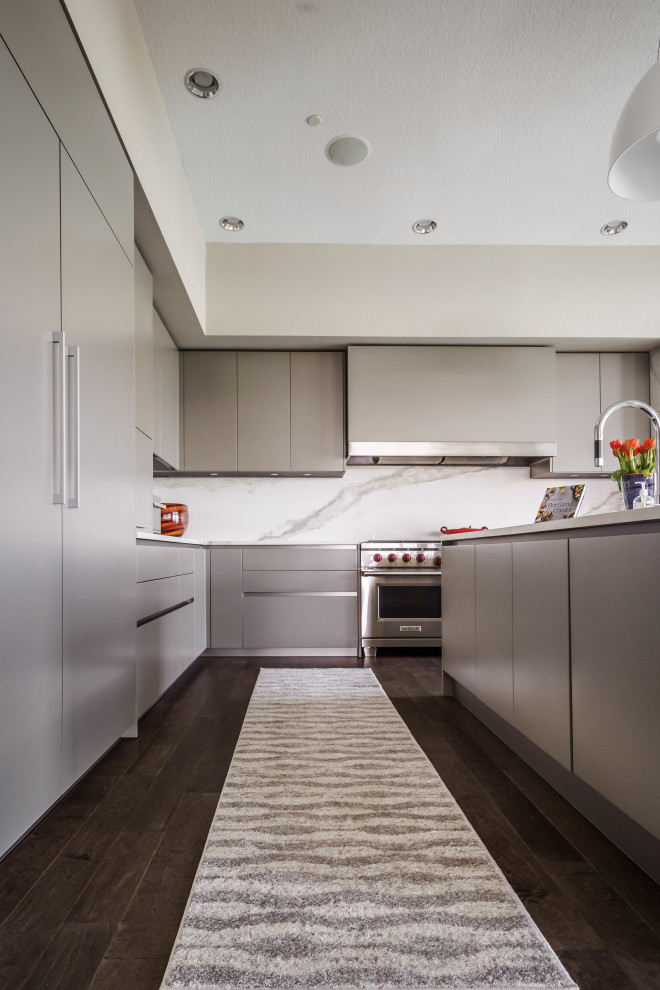 This is an example of a large contemporary l-shaped open plan kitchen in Portland with an undermount sink, flat-panel cabinets, grey cabinets, quartz benchtops, white splashback, stone slab splashback, panelled appliances, dark hardwood floors, with island, brown floor and white benchtop.