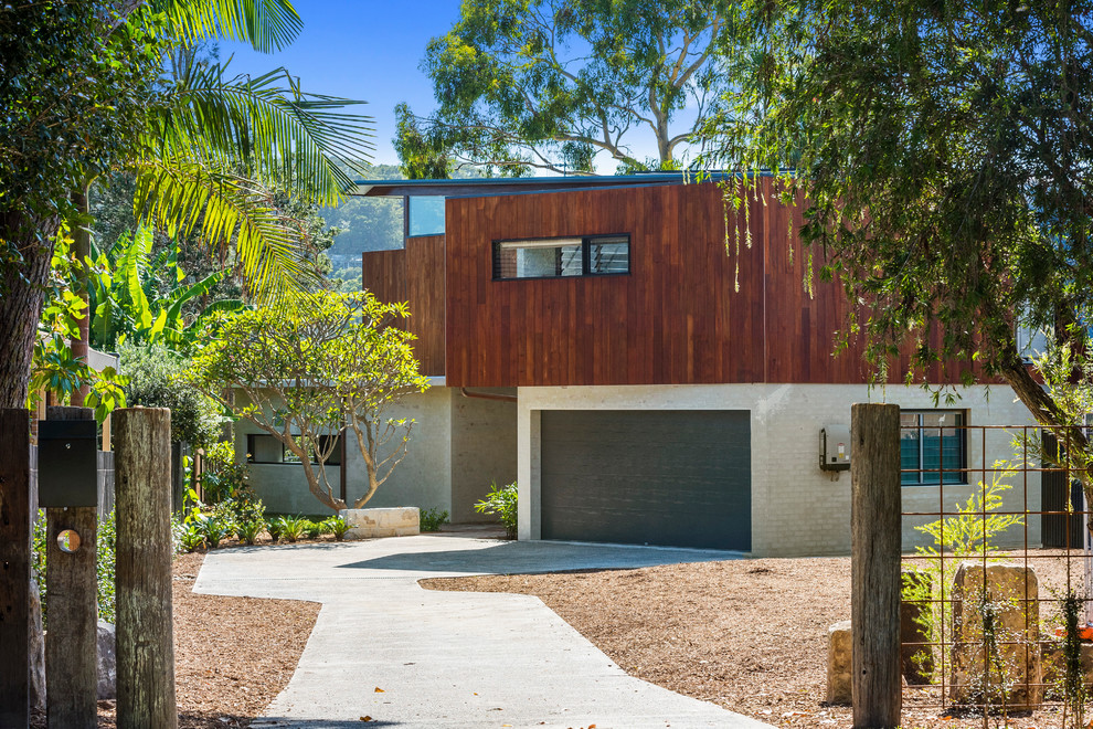 Photo of a large contemporary two-storey brown house exterior in Sydney with wood siding, a metal roof and a shed roof.