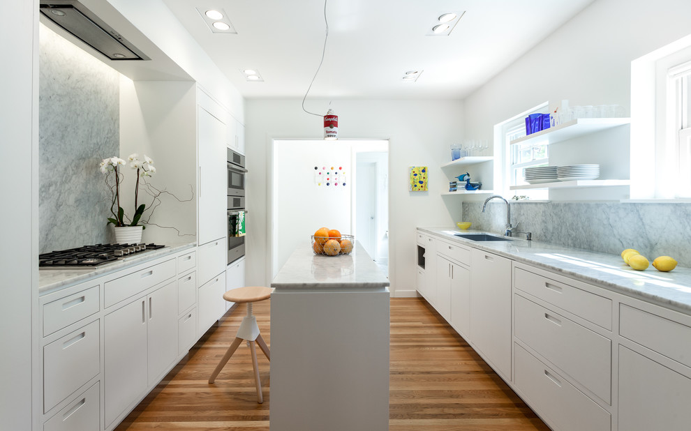 Inspiration for a mid-sized contemporary galley kitchen in Sacramento with a single-bowl sink, flat-panel cabinets, white cabinets, marble benchtops, grey splashback, stone slab splashback, panelled appliances, medium hardwood floors and with island.
