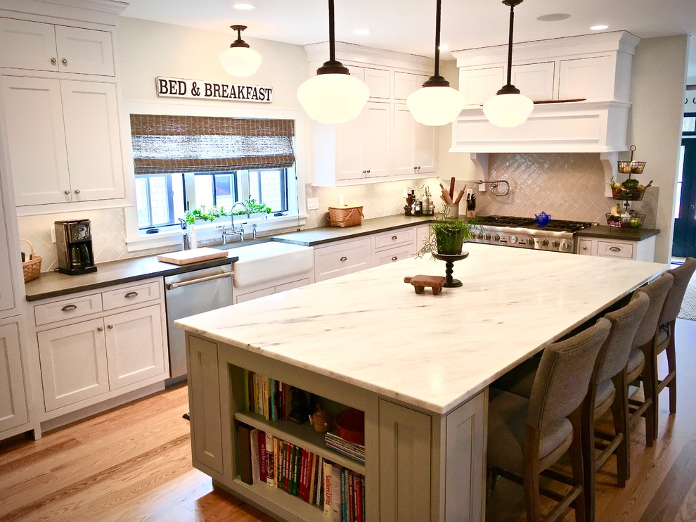 Transitional light wood floor and brown floor kitchen photo in New York with a farmhouse sink, white cabinets, concrete countertops, white backsplash, porcelain backsplash and stainless steel appliances
