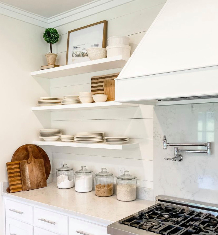 Design ideas for a medium sized country l-shaped kitchen/diner in Atlanta with a belfast sink, shaker cabinets, white cabinets, quartz worktops, white splashback, tonge and groove splashback, stainless steel appliances, an island and white worktops.