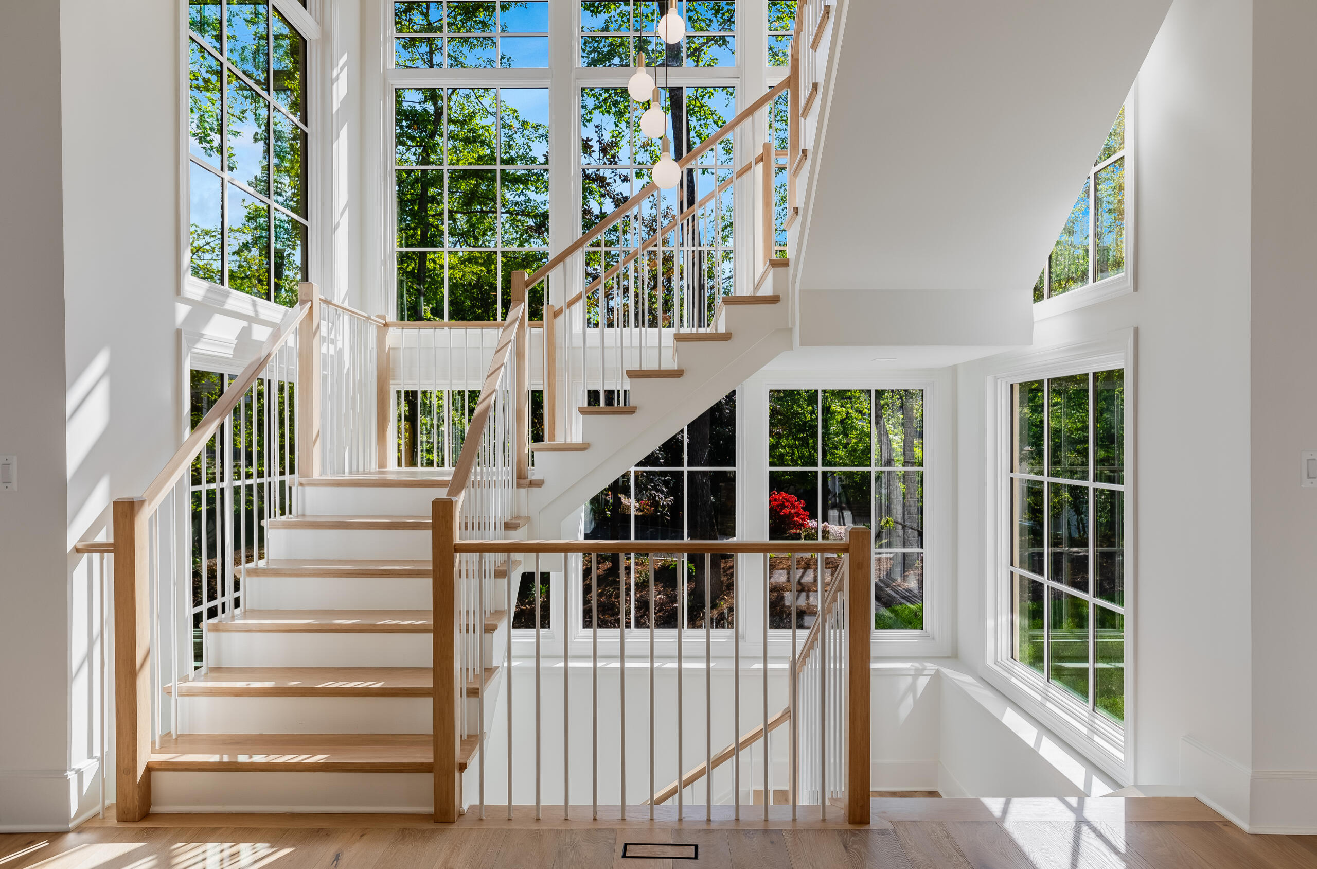 Project #152 | Three-Story White Oak Staircase with a Pendant Chandelier