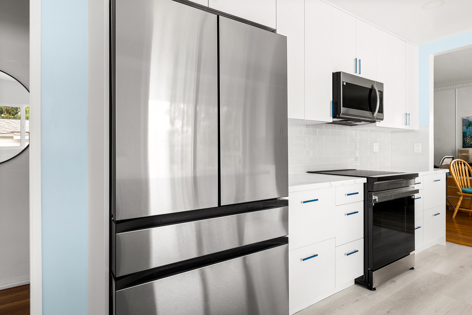 Appliances, Cabinetry, Tile Backsplash, and Plank Vinyl Laminate Flooring