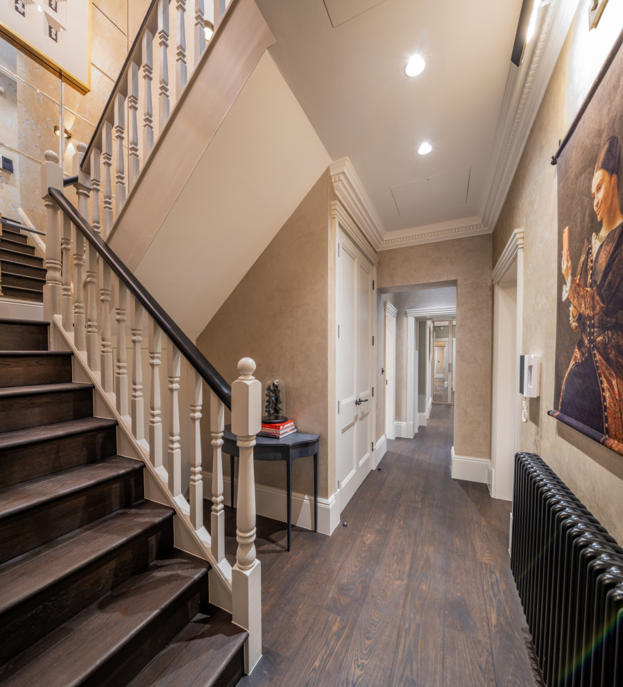 This is an example of a mid-sized traditional hallway in London with beige walls, dark hardwood floors and brown floor.