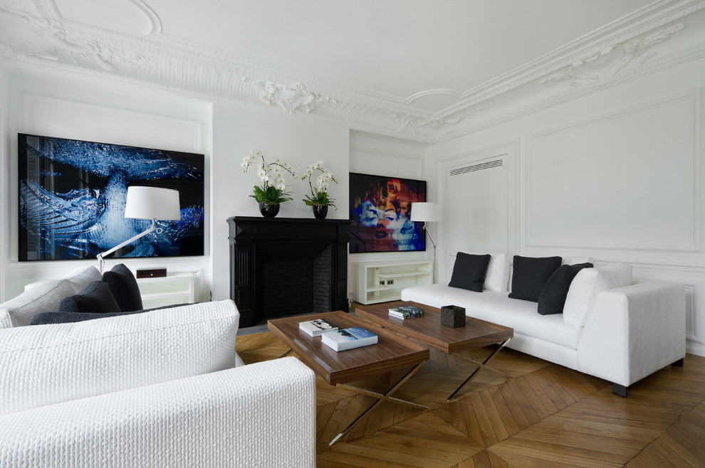 Photo of a large contemporary formal enclosed living room in Paris with white walls, medium hardwood floors, a standard fireplace and no tv.