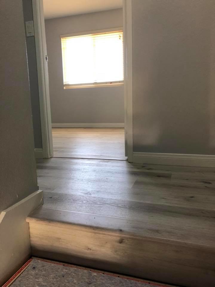 Photo of a beach style hallway in San Diego with grey walls, vinyl floors and grey floor.