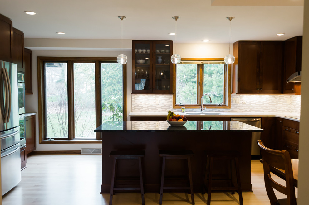 Eat-in kitchen - large transitional l-shaped light wood floor eat-in kitchen idea with an undermount sink, shaker cabinets, dark wood cabinets, quartz countertops, gray backsplash, matchstick tile backsplash, stainless steel appliances and an island