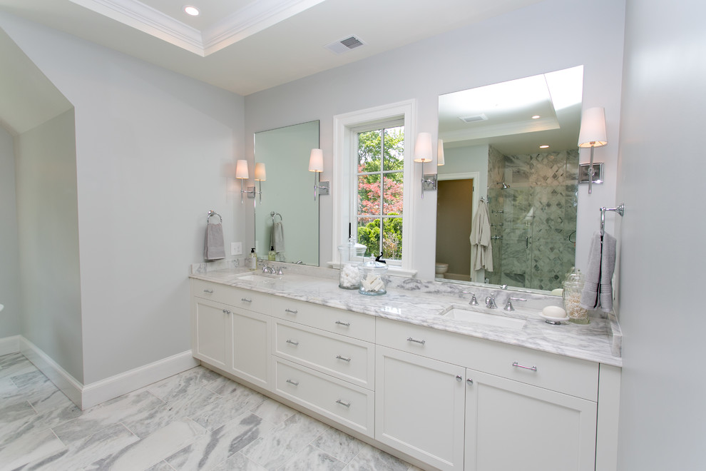 Inspiration for a mid-sized transitional master multicolored tile and marble tile marble floor freestanding bathtub remodel in DC Metro with recessed-panel cabinets, white cabinets, a two-piece toilet, gray walls, an integrated sink and marble countertops