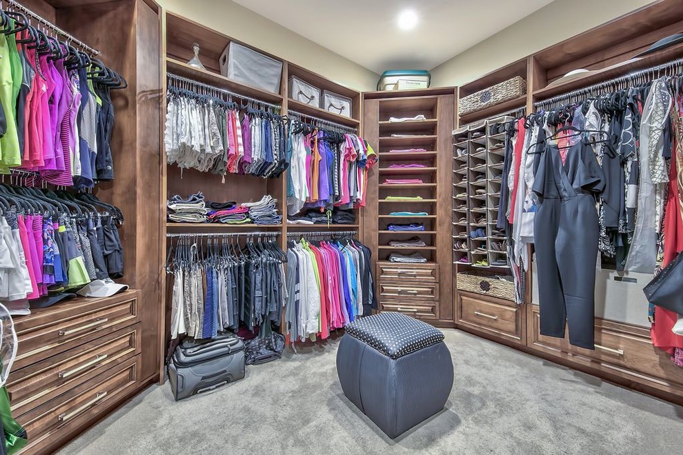 Example of a huge transitional gender-neutral carpeted and gray floor dressing room design with recessed-panel cabinets and medium tone wood cabinets
