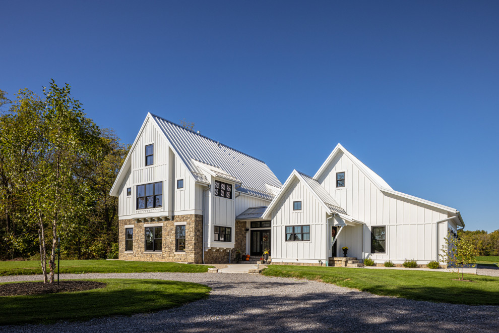 Diseño de fachada de casa blanca y gris campestre grande con revestimiento de aglomerado de cemento, tejado a dos aguas, tejado de metal y panel y listón
