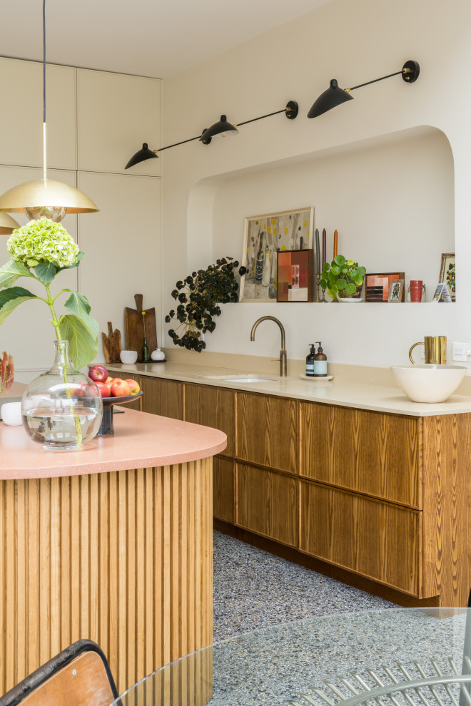 Inredning av ett mellanstort rosa rosa kök, med en integrerad diskho, luckor med infälld panel, skåp i mellenmörkt trä, bänkskiva i koppar, beige stänkskydd, stänkskydd i skiffer, integrerade vitvaror, klinkergolv i keramik, en köksö och grått golv