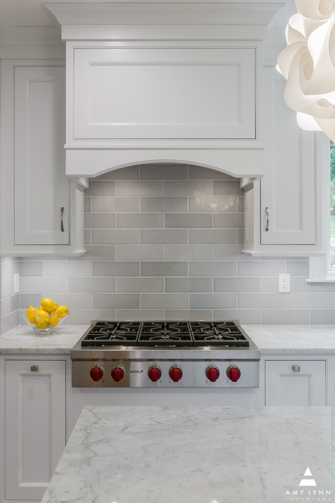 Eat-in kitchen - mid-sized transitional l-shaped medium tone wood floor and red floor eat-in kitchen idea in Boston with an undermount sink, beaded inset cabinets, white cabinets, marble countertops, gray backsplash, porcelain backsplash, paneled appliances, an island and yellow countertops
