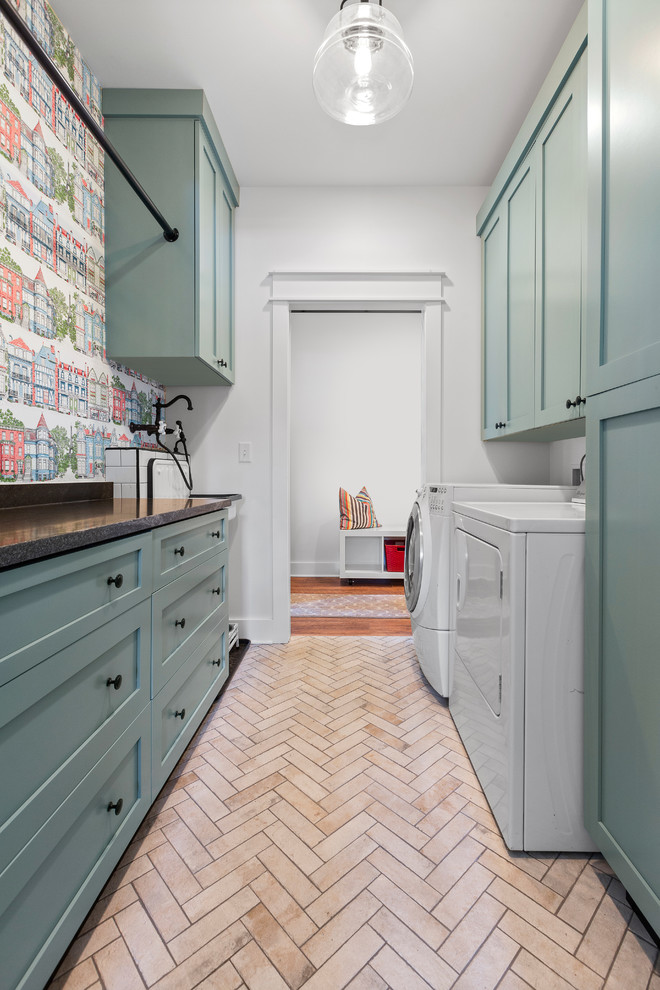 Transitional galley dedicated laundry room in Other with shaker cabinets, green cabinets, multi-coloured walls, a side-by-side washer and dryer, beige floor and black benchtop.