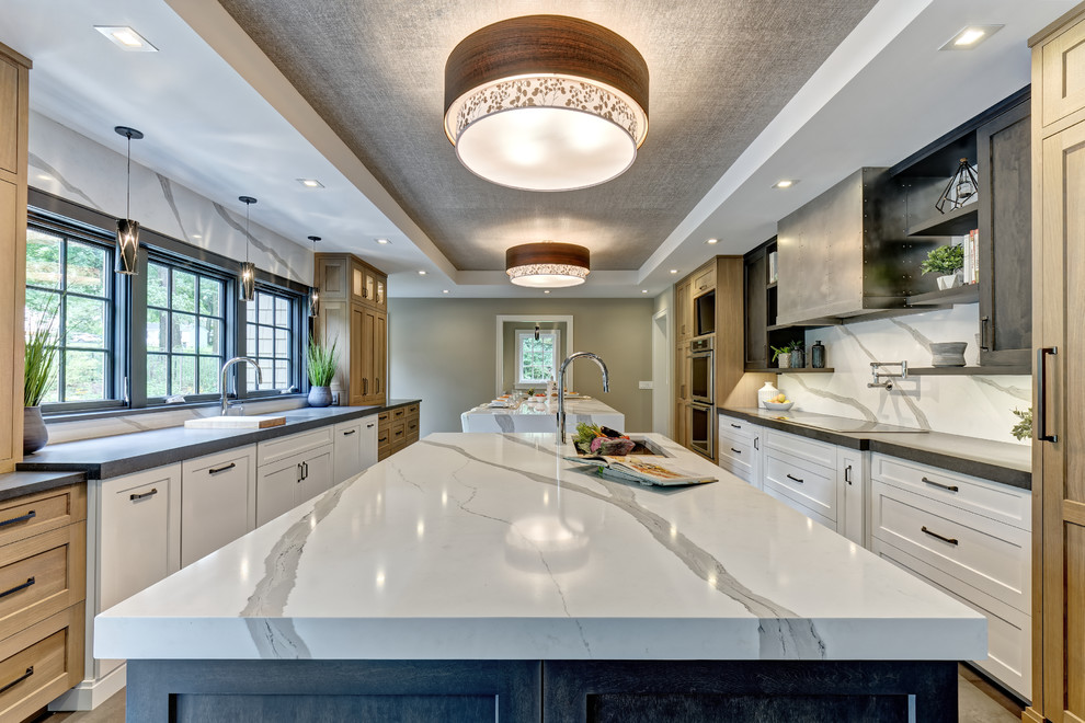 Example of a large transitional galley porcelain tile and brown floor eat-in kitchen design in New York with an undermount sink, shaker cabinets, white cabinets, quartz countertops, white backsplash, stone slab backsplash, stainless steel appliances, two islands and white countertops