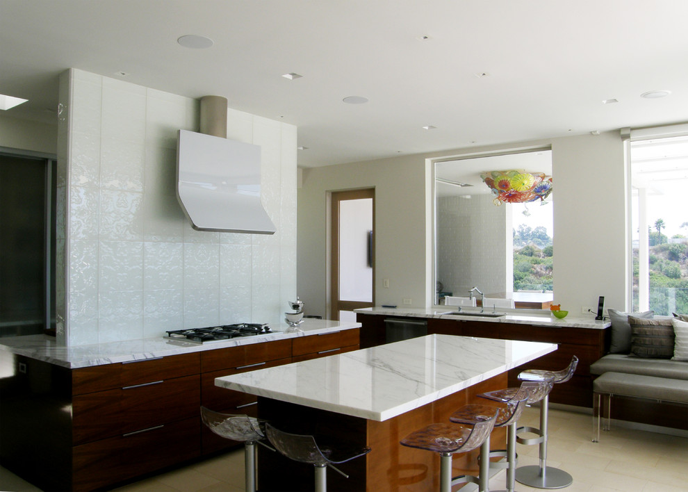 Inspiration for a large contemporary open plan kitchen in San Diego with an undermount sink, flat-panel cabinets, medium wood cabinets, marble benchtops, white splashback, stainless steel appliances, with island and beige floor.