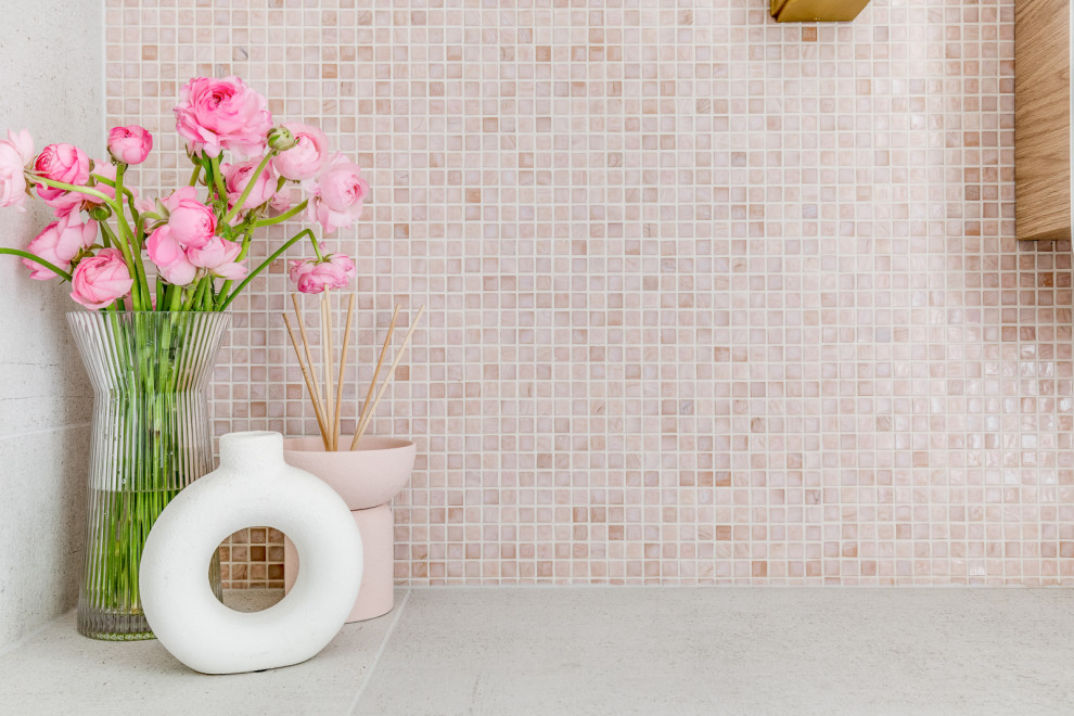 Kleines Shabby-Style Duschbad mit flächenbündigen Schrankfronten, hellen Holzschränken, Duschnische, Toilette mit Aufsatzspülkasten, farbigen Fliesen, rosa Wandfarbe, Aufsatzwaschbecken, grauem Boden, Falttür-Duschabtrennung, weißer Waschtischplatte, Einzelwaschbecken und schwebendem Waschtisch in Sydney