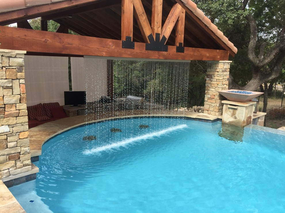 Large mountain style backyard custom-shaped infinity hot tub photo in Austin with decking