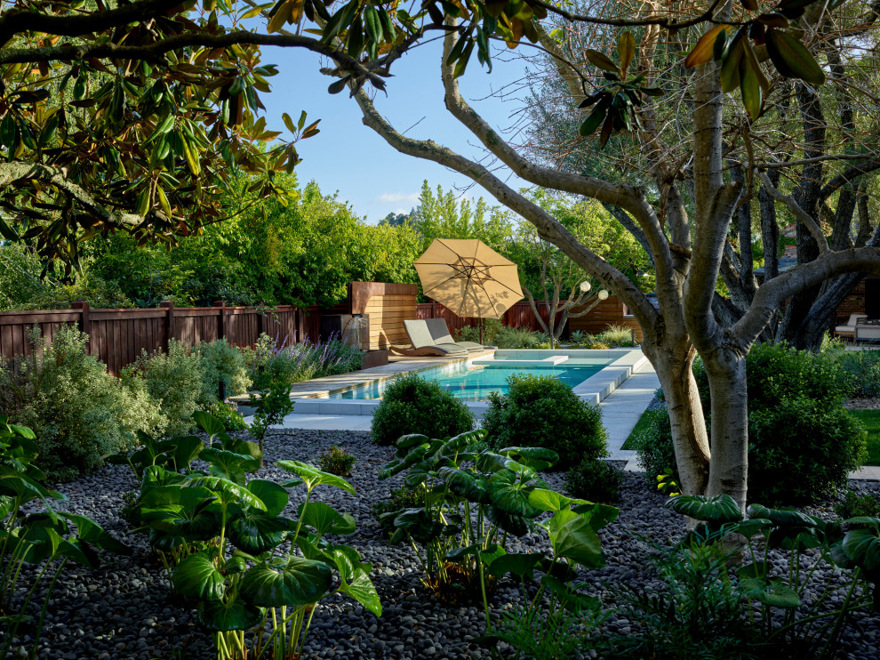 This is an example of a french country partial sun backyard river rock and wood fence landscaping in San Francisco for summer.