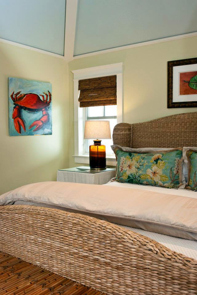 Mid-sized beach style guest bedroom in Miami with yellow walls and brown floor.