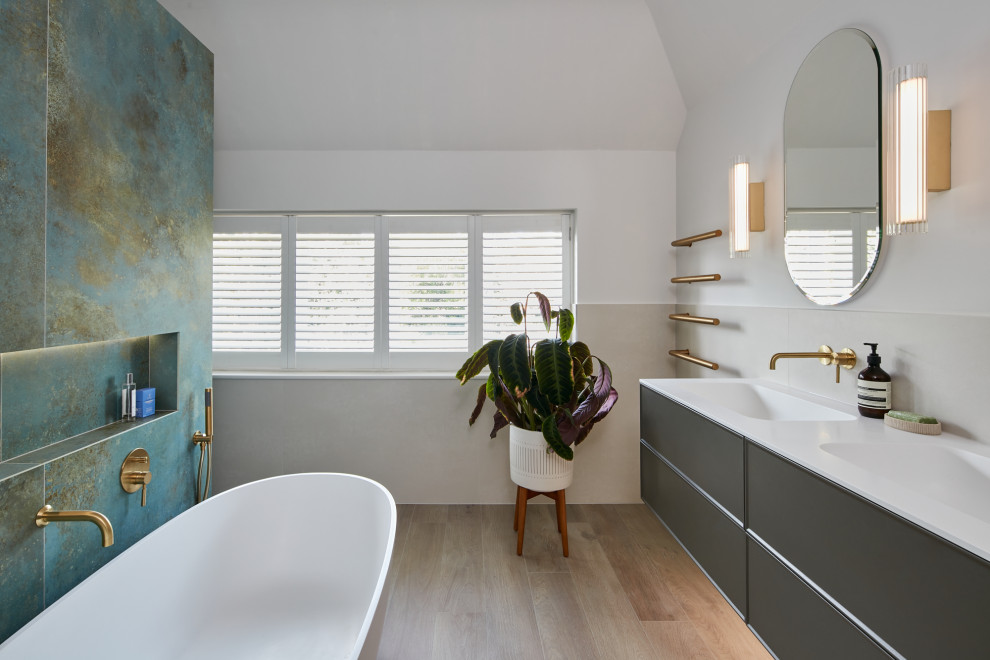 На фото: большая главная ванная комната в стиле модернизм с отдельно стоящей ванной, зеленой плиткой, монолитной раковиной, душем с распашными дверями, тумбой под две раковины и подвесной тумбой с
