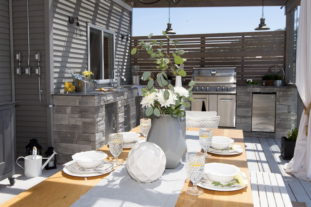 Example of a large transitional backyard outdoor kitchen deck design in Vancouver with a pergola