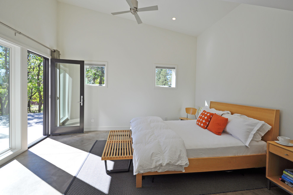 This is an example of a large contemporary master bedroom in Albuquerque with concrete floors and white walls.