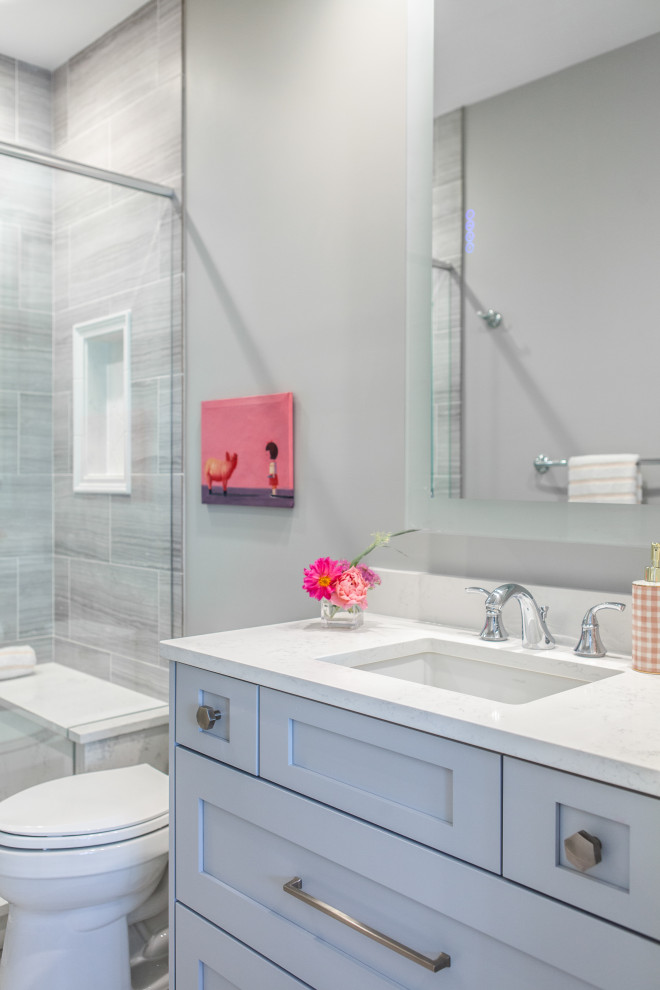 Design ideas for a transitional kids bathroom in Chicago with recessed-panel cabinets, white cabinets, a one-piece toilet, white tile, subway tile, grey walls, porcelain floors, an undermount sink, quartzite benchtops, white floor, a hinged shower door and white benchtops.