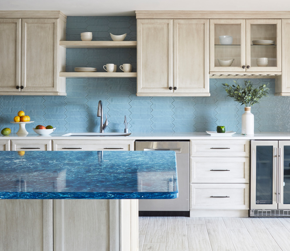 Large transitional l-shaped open plan kitchen with an undermount sink, recessed-panel cabinets, grey cabinets, quartz benchtops, blue splashback, glass tile splashback, stainless steel appliances, porcelain floors, with island, grey floor and blue benchtop.