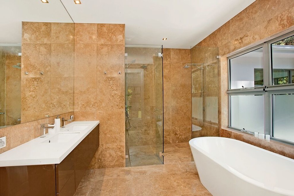 This is an example of a mid-sized contemporary master bathroom in Sydney with flat-panel cabinets, brown cabinets, a freestanding tub, a double shower, brown tile, travertine, travertine floors, an undermount sink, engineered quartz benchtops, brown floor and a hinged shower door.