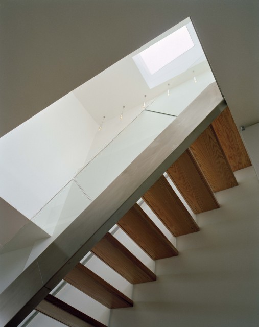Photo of a mid-sized contemporary wood straight staircase in New York with glass risers and metal railing.