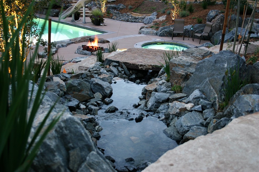 Large contemporary backyard garden in Other with a fire feature and concrete pavers.