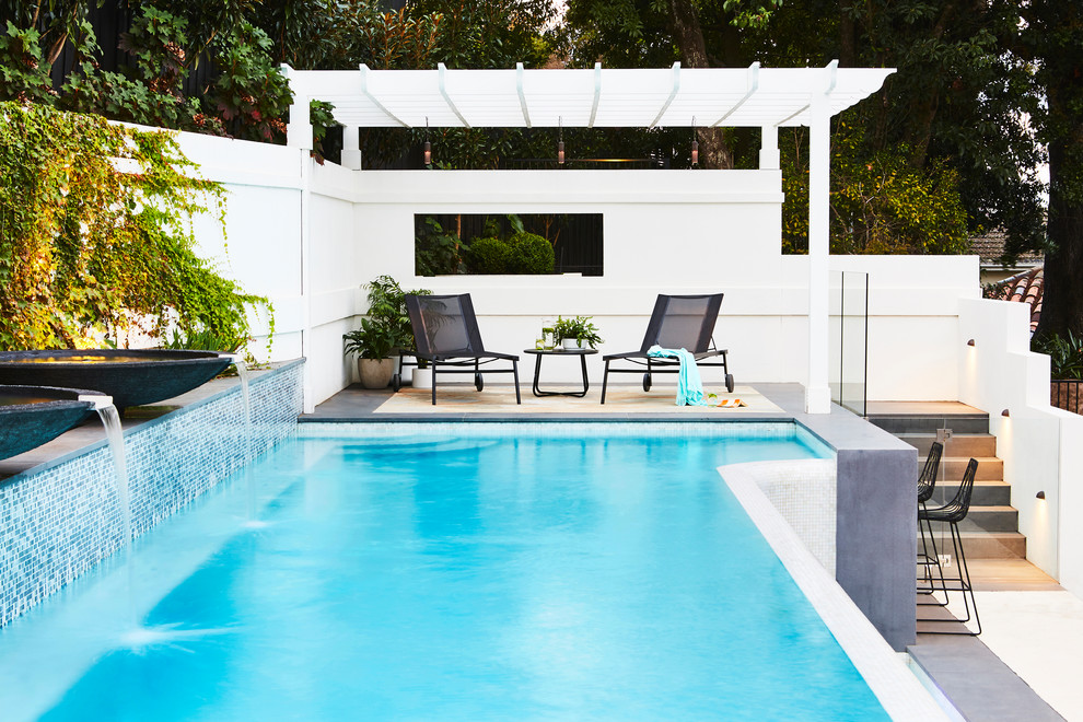 Contemporary custom-shaped pool in Melbourne with a water feature and concrete pavers.