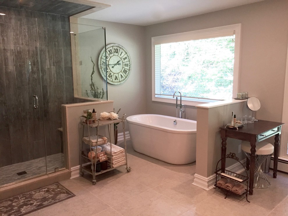 Photo of a large transitional master bathroom in New York with recessed-panel cabinets, dark wood cabinets, a freestanding tub, an open shower, a one-piece toilet, beige tile, porcelain tile, grey walls, porcelain floors, an undermount sink and marble benchtops.