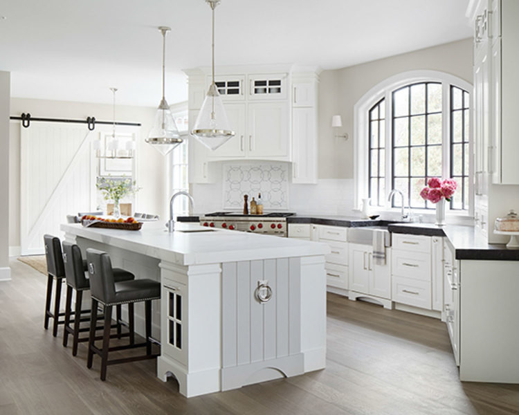 Photo of a large transitional galley separate kitchen in Chicago with white cabinets, with island, flat-panel cabinets, marble benchtops, white splashback, glass tile splashback, panelled appliances, medium hardwood floors and a farmhouse sink.