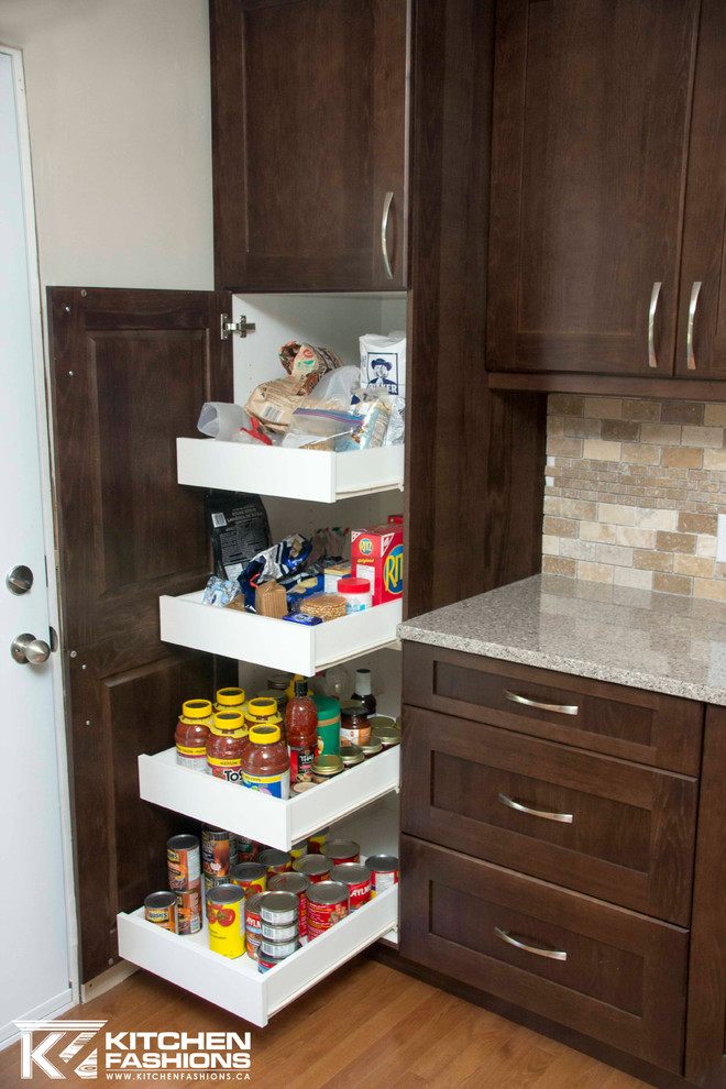 Open concept kitchen - large transitional u-shaped medium tone wood floor open concept kitchen idea with a farmhouse sink, shaker cabinets, dark wood cabinets, quartz countertops, brown backsplash, stone tile backsplash, stainless steel appliances and an island