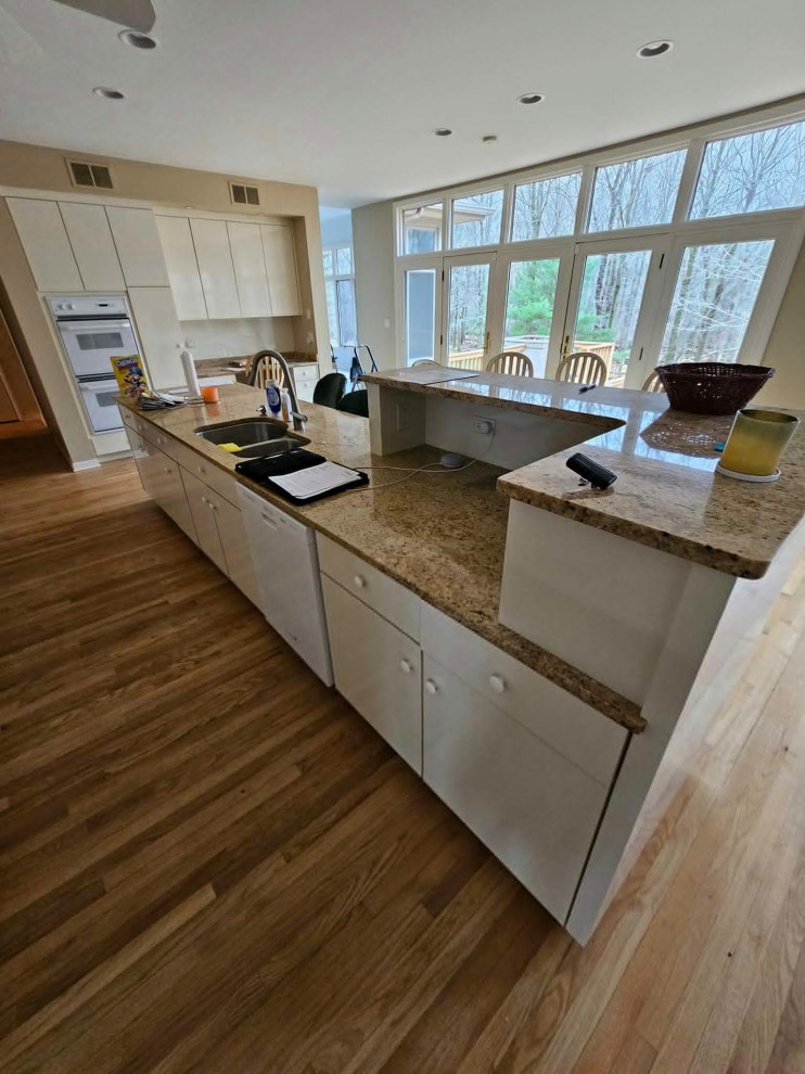 Inspiration for a large transitional medium tone wood floor and brown floor eat-in kitchen remodel in Chicago with an undermount sink, shaker cabinets, medium tone wood cabinets, quartz countertops, multicolored backsplash, stone tile backsplash, stainless steel appliances, an island and white countertops
