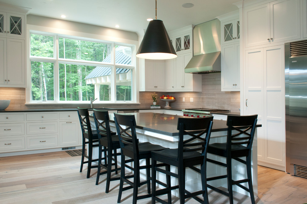 Inspiration for a mid-sized transitional l-shaped light wood floor and beige floor eat-in kitchen remodel with an undermount sink, shaker cabinets, white cabinets, solid surface countertops, multicolored backsplash, porcelain backsplash, stainless steel appliances and an island