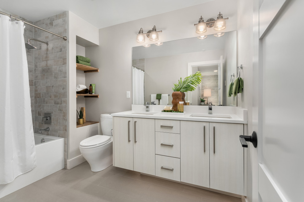Design ideas for a mid-sized contemporary bathroom in Seattle with flat-panel cabinets, white cabinets, a shower/bathtub combo, a one-piece toilet, gray tile, ceramic floors, an undermount sink, grey floor, white benchtops, grey walls and a shower curtain.