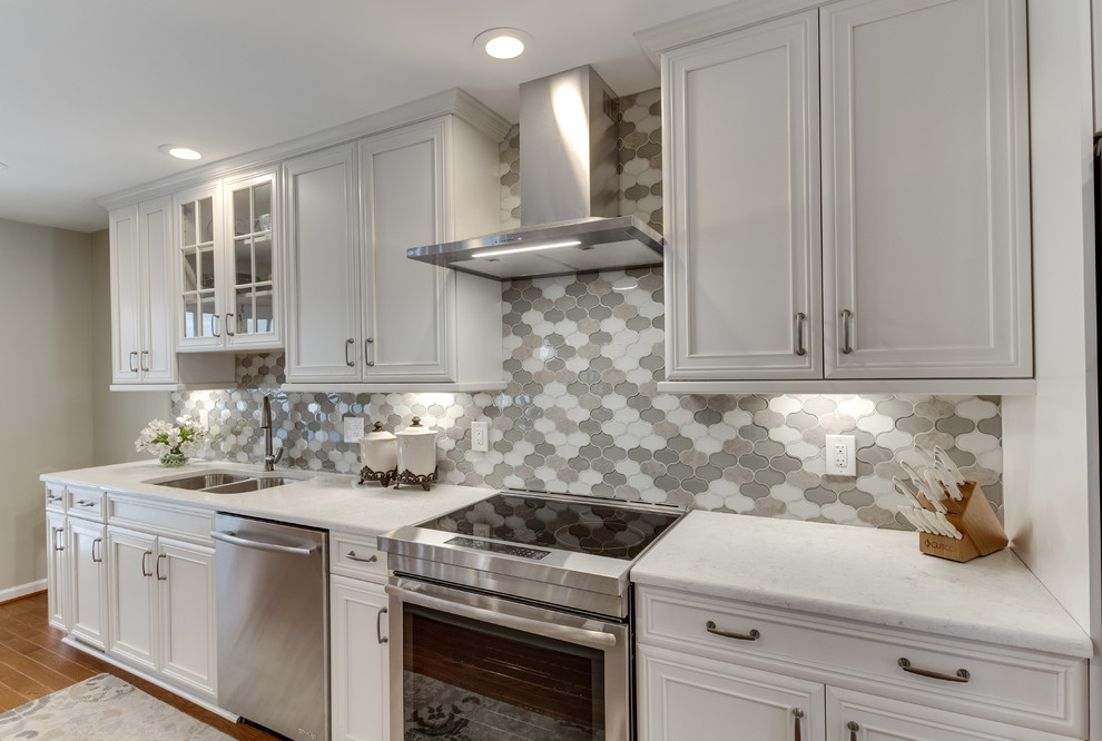 Design ideas for a large traditional galley kitchen in DC Metro with an undermount sink, recessed-panel cabinets, quartz benchtops, stainless steel appliances, medium hardwood floors and with island.