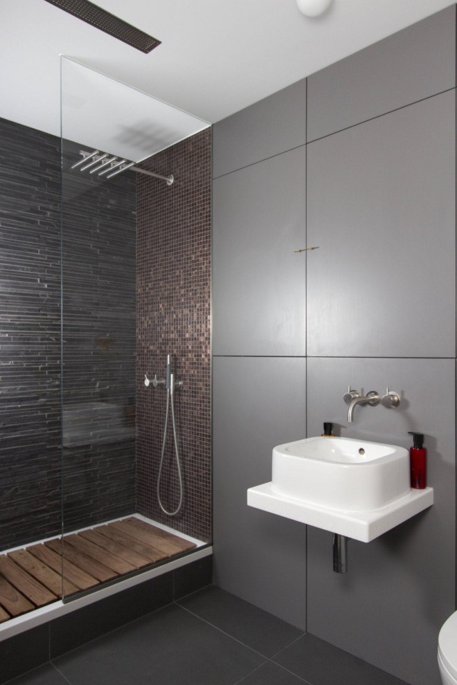 Modelo de cuarto de baño principal y único urbano de tamaño medio con ducha abierta, baldosas y/o azulejos grises, paredes grises, lavabo suspendido, ducha abierta y encimeras blancas