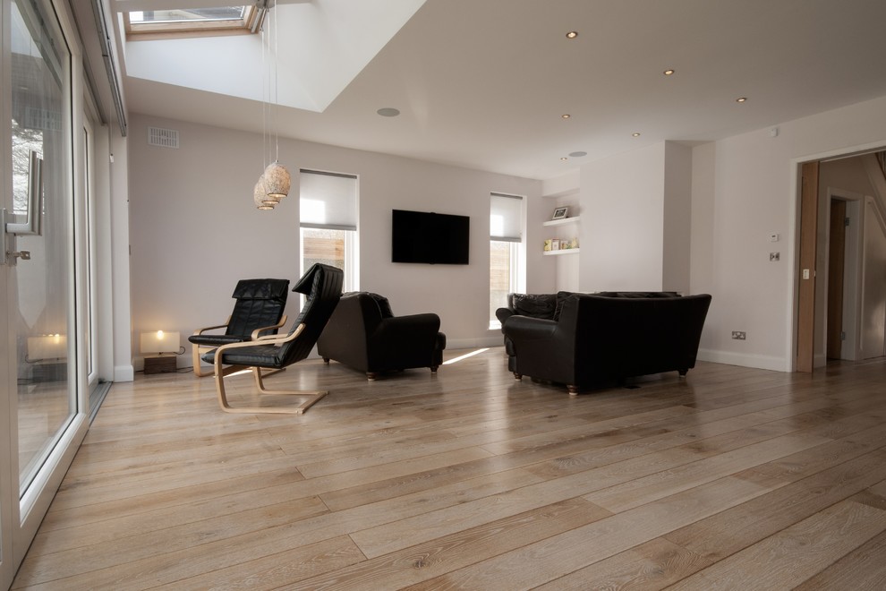 Photo of a large contemporary open concept living room in Dublin with a home bar, white walls, medium hardwood floors and a wall-mounted tv.
