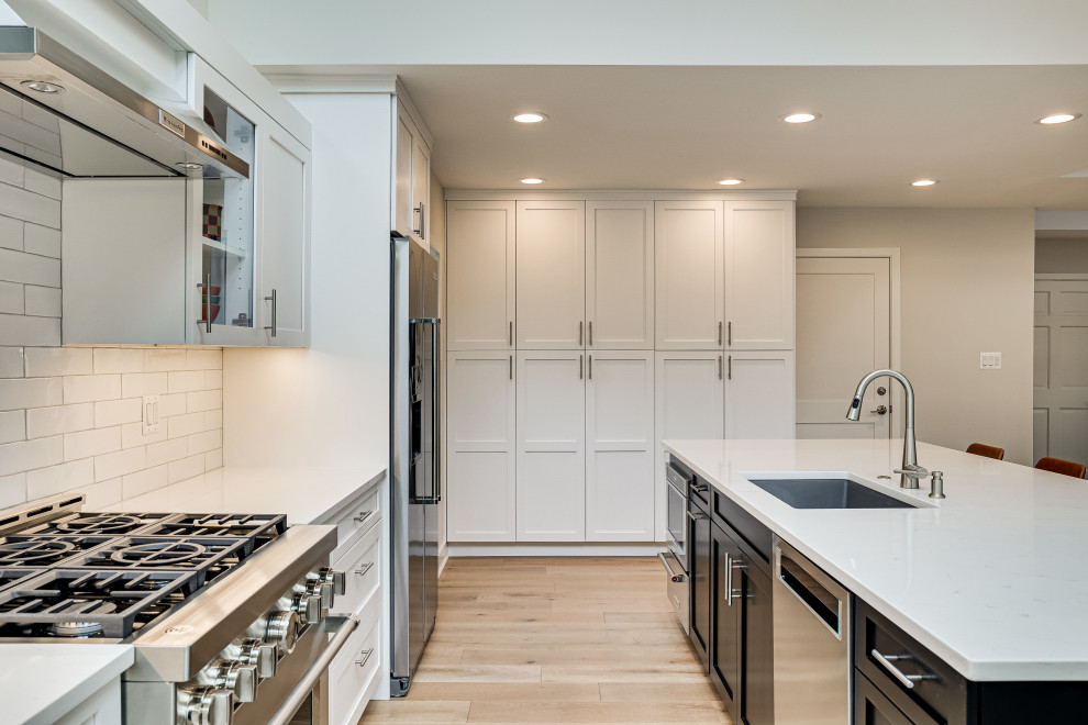 Small contemporary l-shaped kitchen pantry in DC Metro with an undermount sink, shaker cabinets, quartz benchtops, stainless steel appliances and with island.
