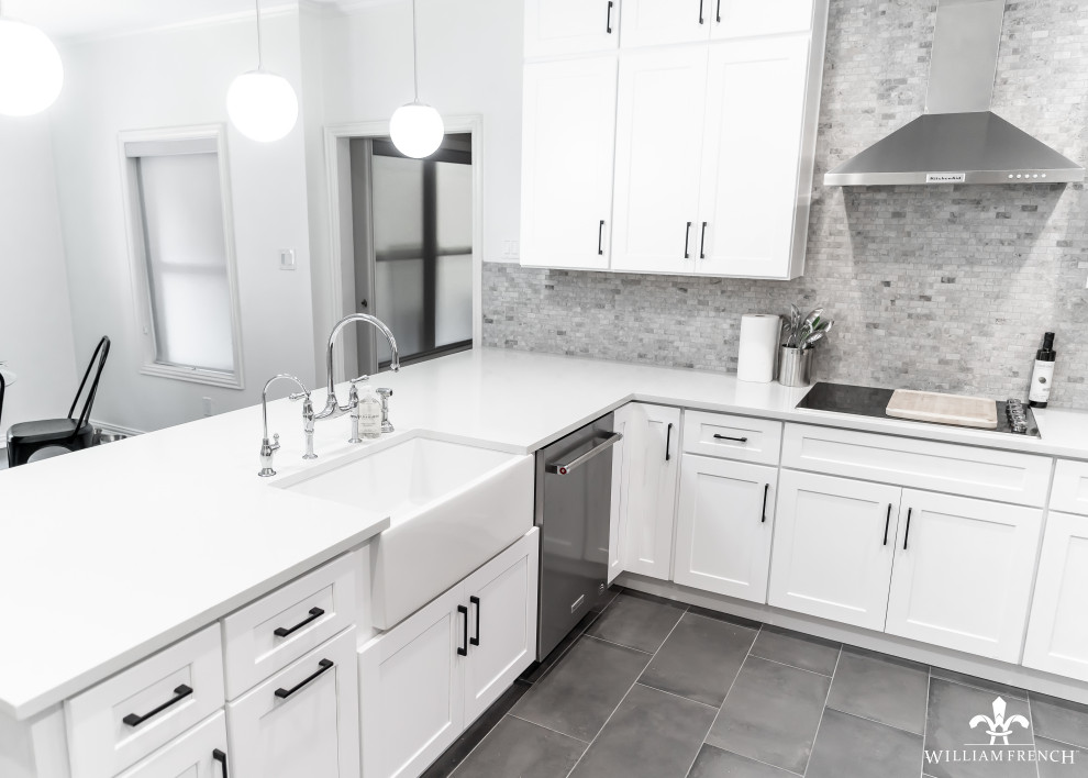 Design ideas for a medium sized modern u-shaped kitchen/diner in Dallas with a belfast sink, shaker cabinets, white cabinets, engineered stone countertops, grey splashback, stone tiled splashback, stainless steel appliances, ceramic flooring, no island, grey floors and white worktops.