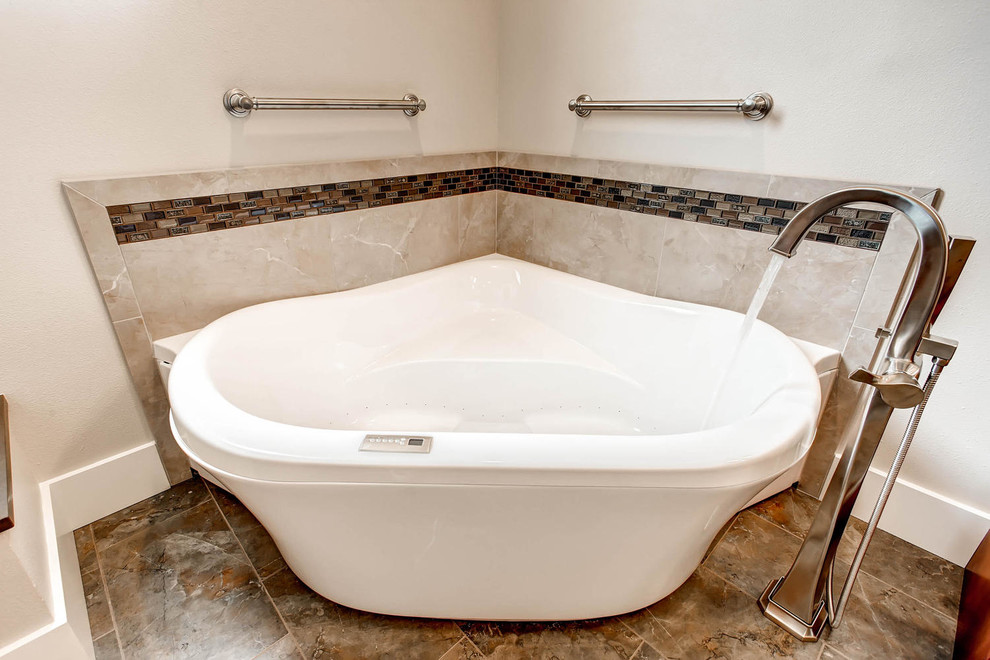 Corner bathtub - mid-sized transitional gray tile and porcelain tile porcelain tile corner bathtub idea in Denver with shaker cabinets, medium tone wood cabinets, a one-piece toilet, gray walls, an undermount sink and solid surface countertops